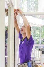 A technician hanging 3M Envision™ window film on a home