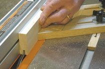 Building cabinet doors - Making the first pass over the blade to cut the groove.