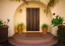 Dark brown front door recessed into the front foyer